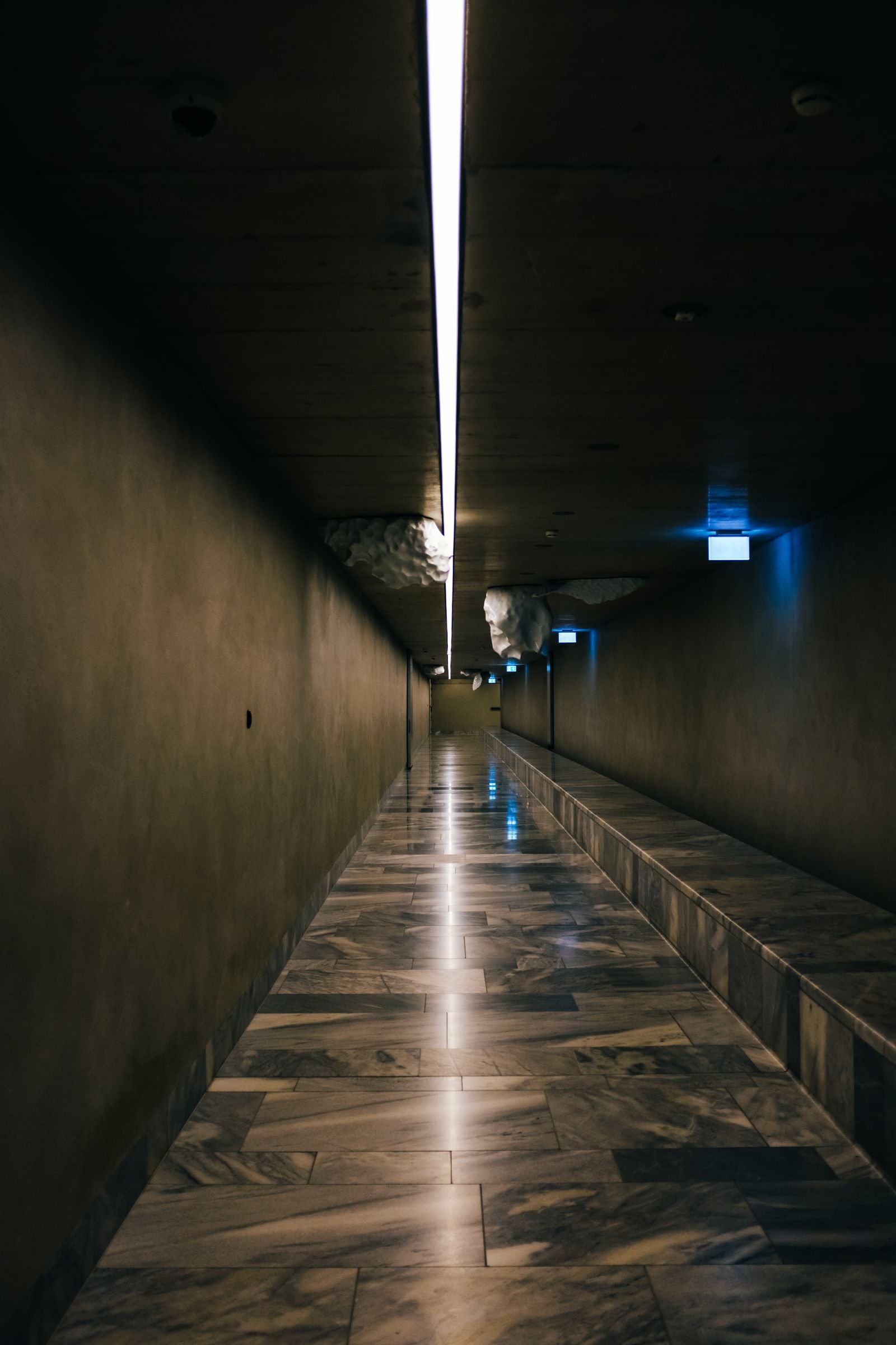 Corredor com piso polido refletindo iluminação — referência visual