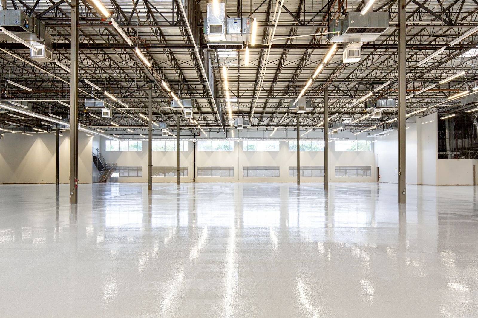 Piso epóxi com acabamento espelhado em galpão industrial — referência visual