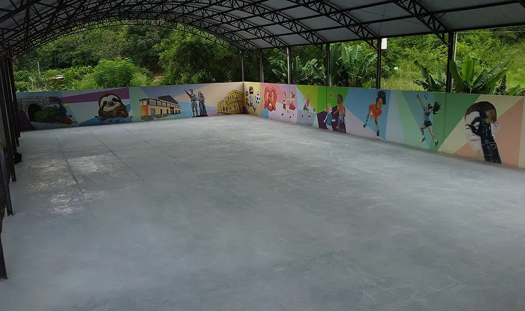 Piso de concreto polido executado pela AMC Engenharia em quadra coberta, superfície contínua refletindo a estrutura metálica da cobertura